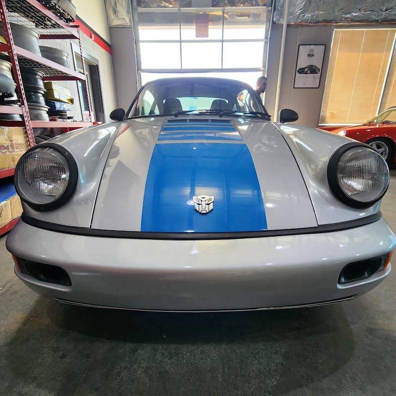 Silver sports car with blue hood stripe and robot emblem at Audio Envy Automotive Design in Manassas, Virginia