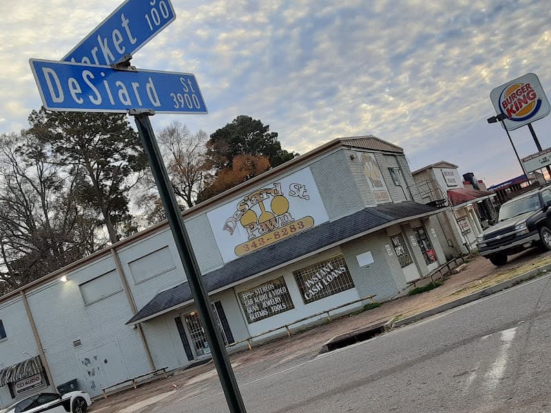 Street signs at a corner beside a white pawn shop building at Desiard St Pawn & Car Audio in Monroe, Louisiana
