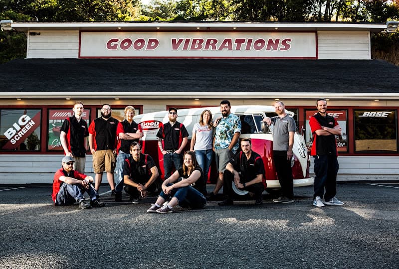 Staff team posing in front of shop with red and white van at Good Vibrations in Roseburg, Oregon