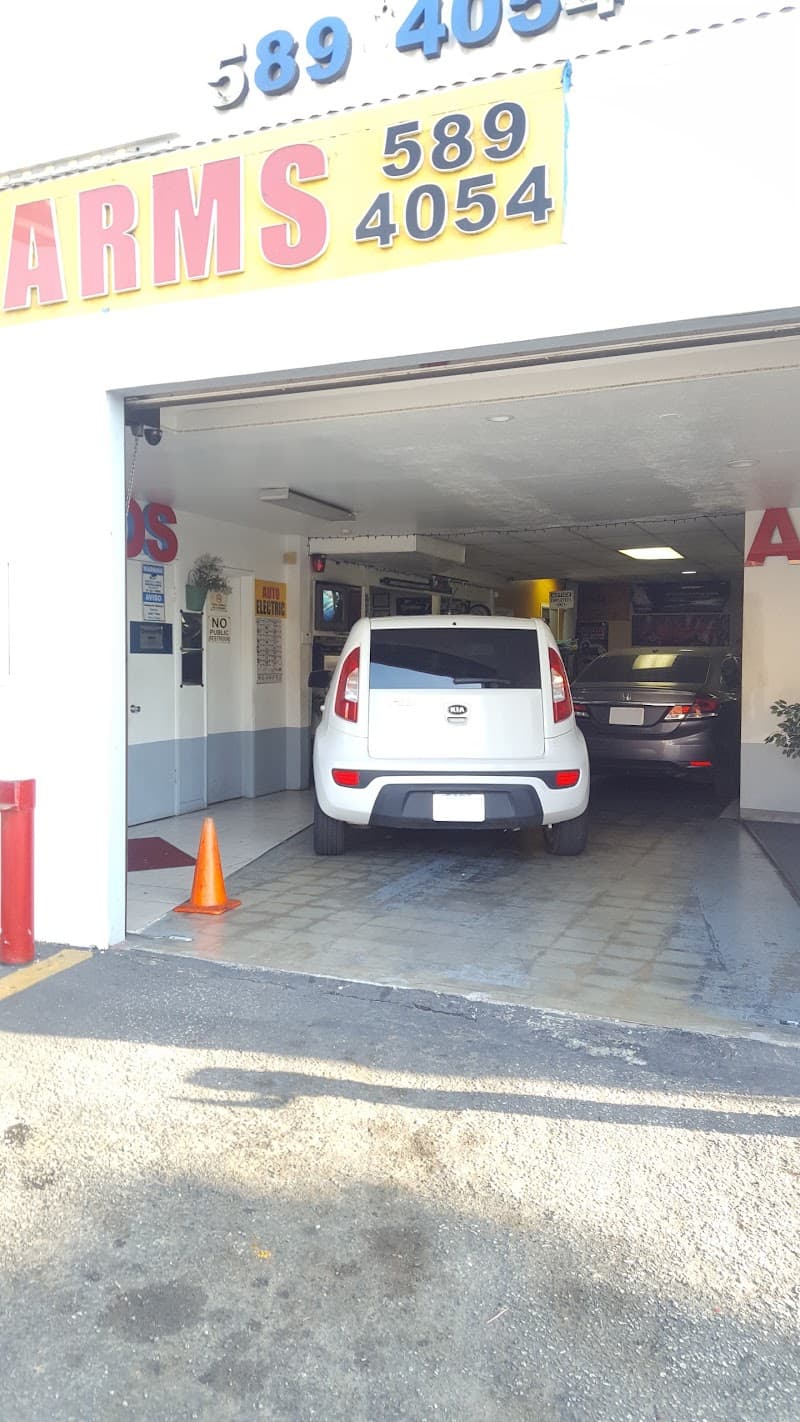 Open garage bay with white Kia hatchback parked inside at Molina Car Stereo in Los Angeles, California
