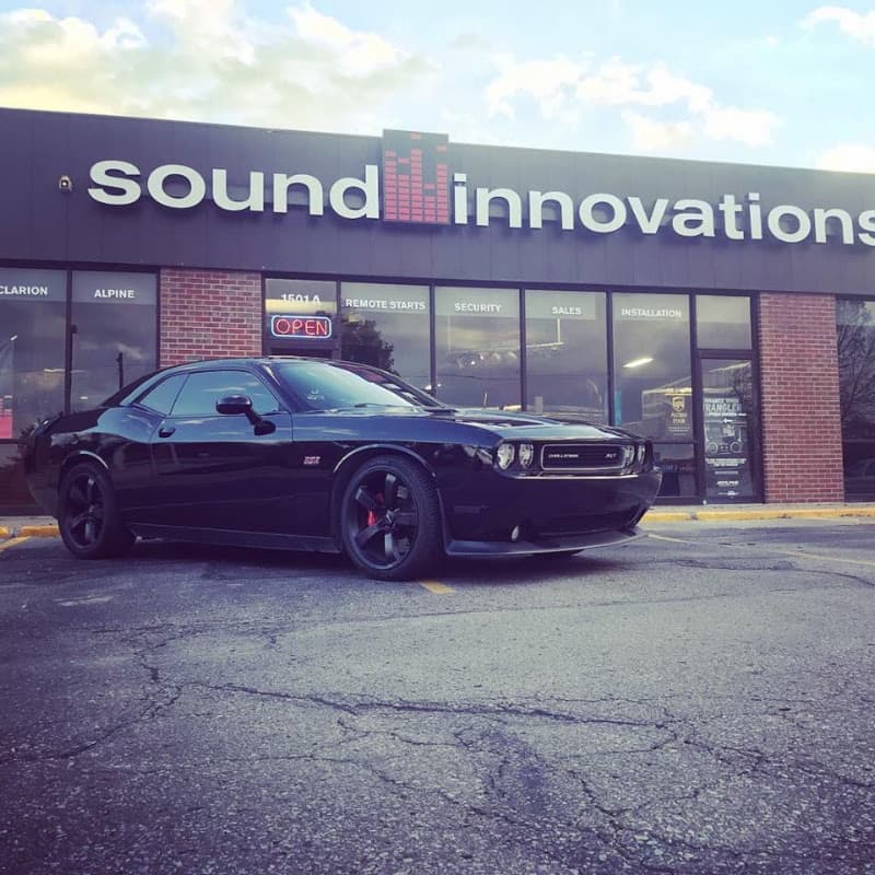 Black Challenger coupe parked in front of storefront at Sound Innovations LLC in Lawrence, Kansas