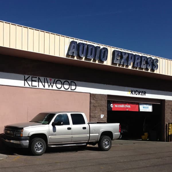 Storefront with open service bay and pickup truck parked outside at Audio Express in Santa Fe, New Mexico