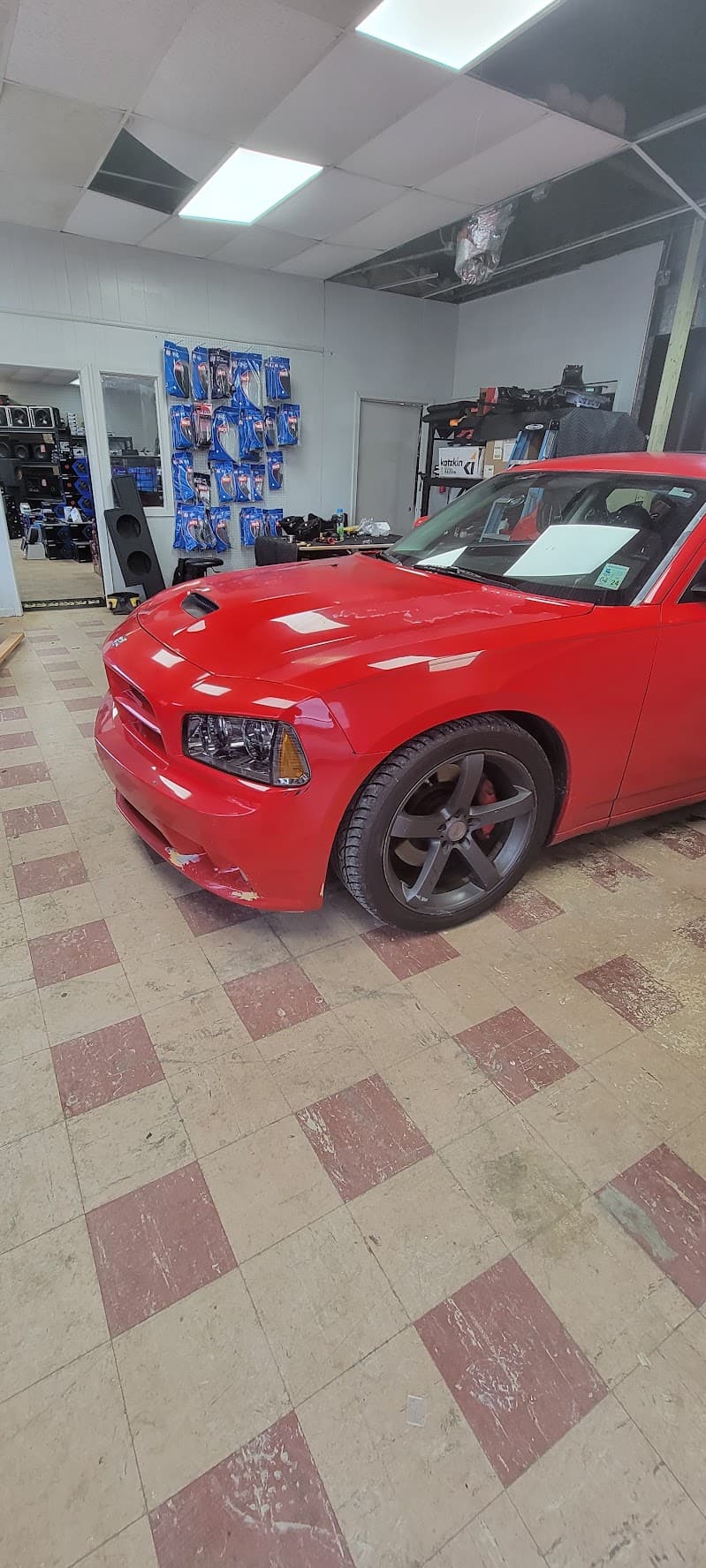 Red sedan with dark wheels parked inside a shop at Auto Trends Audio, Tint, & Acc. in Vicksburg, Mississippi