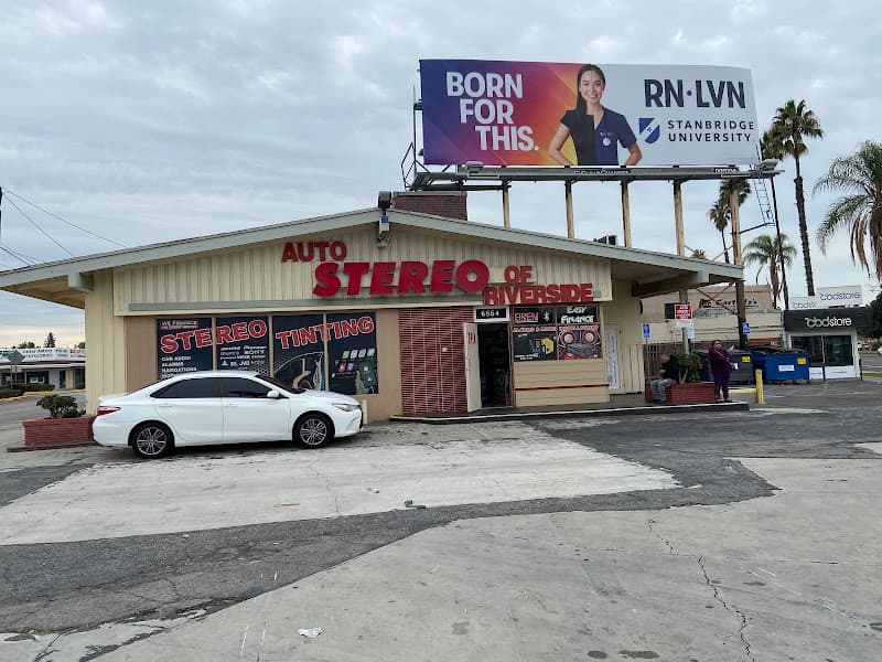 Storefront with red sign and white sedan out front at Auto Stereo of Riverside in Riverside, California