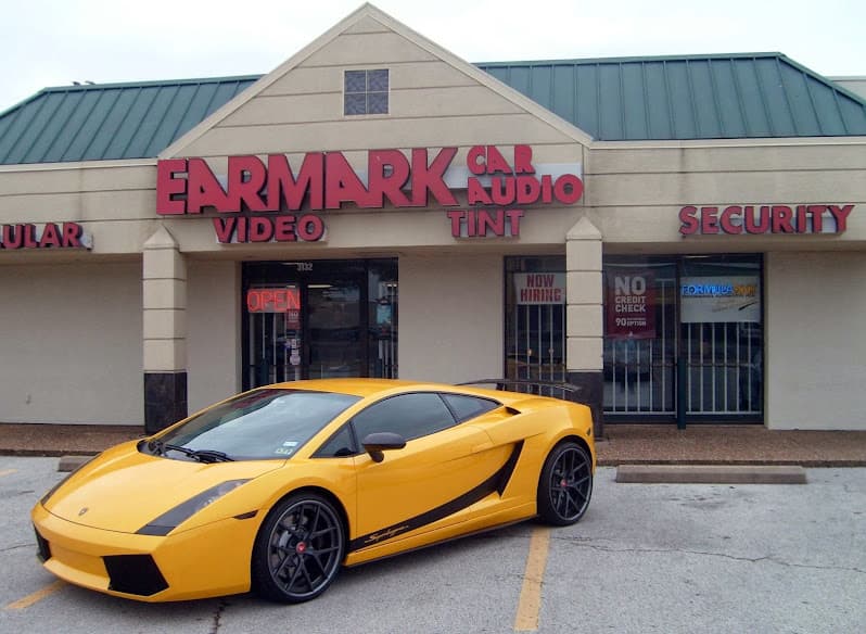 Yellow sports car parked in front of a storefront at Earmark Car Audio & Tint in Plano, Texas