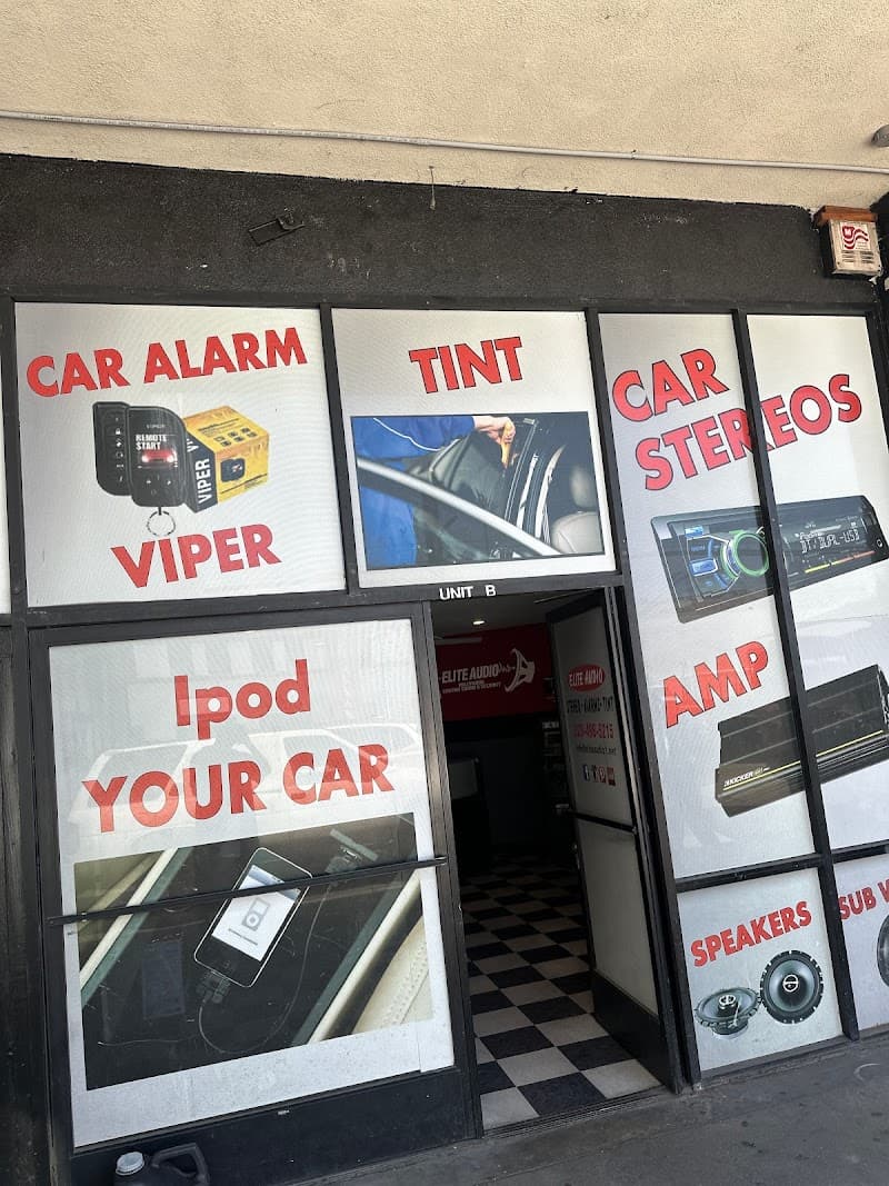 Storefront with window signs for car alarms, tint, and stereos at Elite Audio Hollywood in Los Angeles, California