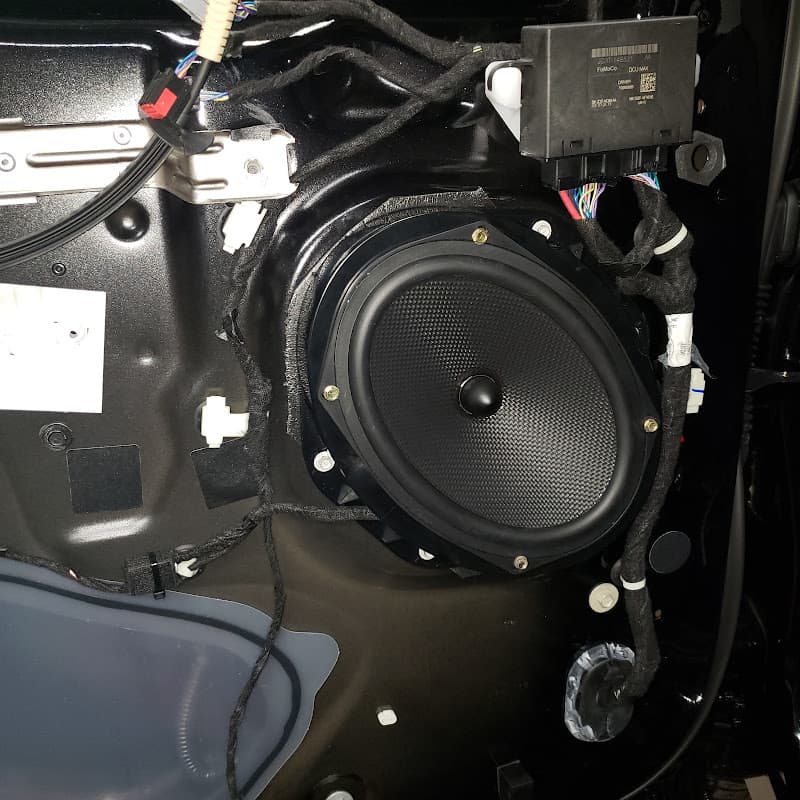 Speaker mounted in a car door panel with wiring around it at Starlander Beck in Milford, Connecticut