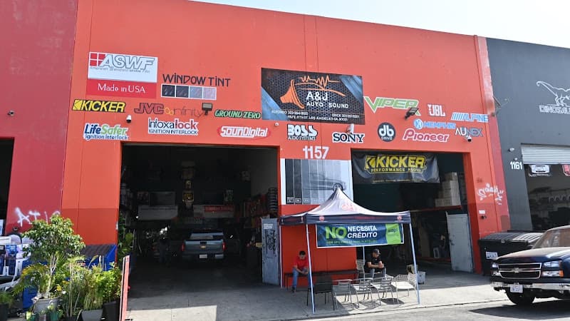 Orange building facade covered in car audio brand logos at AJAUTOSOUND in Los Angeles, California