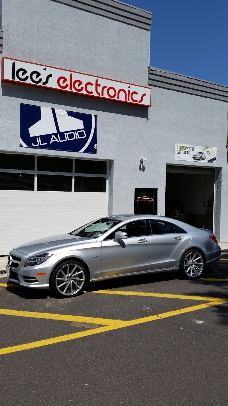 Silver Mercedes sedan parked outside a shop with JL Audio signs at Lee's Electronics in East Brunswick, New Jersey