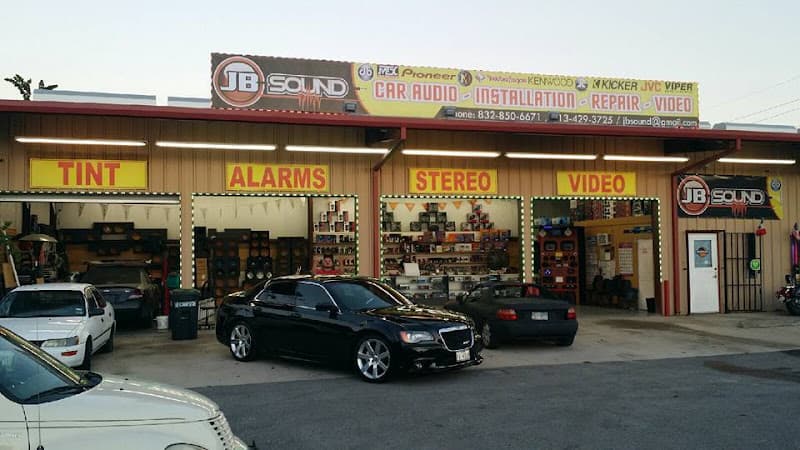 Storefront with yellow TINT, ALARMS and STEREO signs at JB Sound in Houston, Texas