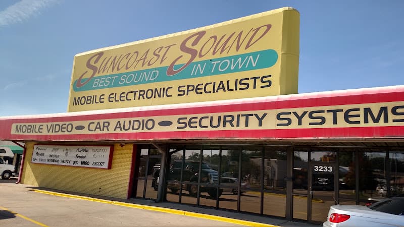 Storefront with yellow sign and red awning above glass doors at Suncoast Sound in Monroe, Louisiana