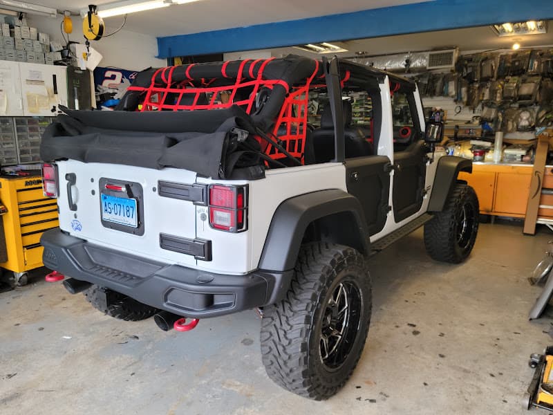 Rear view of white open-top SUV with red netting in a garage at A J's Car Audio in Terryville, Connecticut