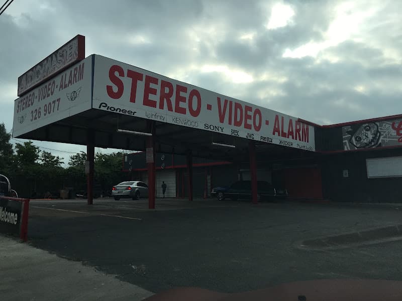 Storefront with red Stereo Video Alarm sign and brand logos at Audiomaster in Austin, Texas