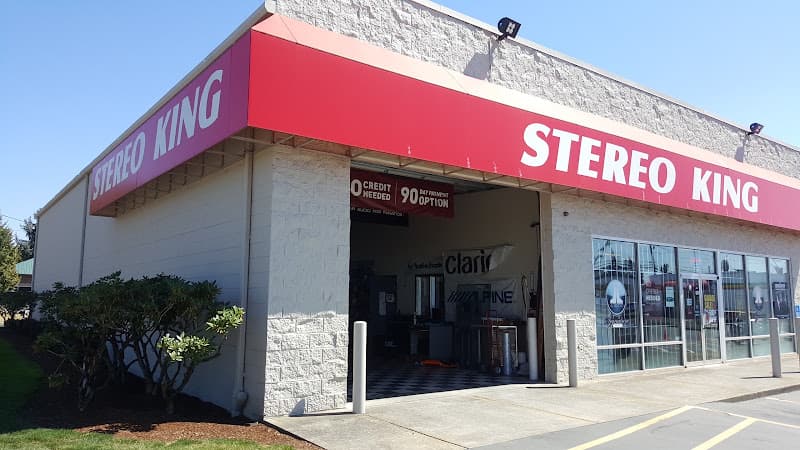 Storefront with red signs and an open bay door at Stereo King Salem in Salem, Oregon