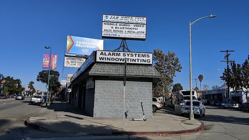 Corner storefront with alarm and window tinting signs at International Auto Radio in North Hollywood, California