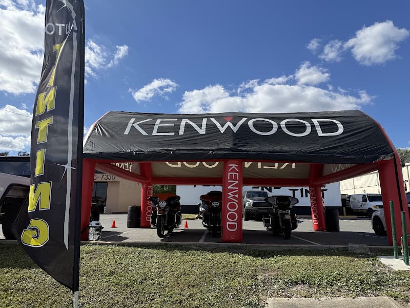 Black and red Kenwood inflatable canopy over parked motorcycles at Tunes-N-Tint in Lakeland, Florida
