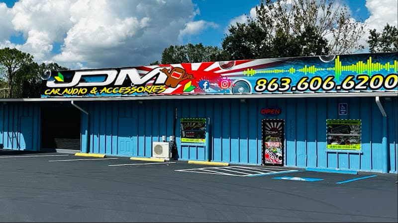 Blue storefront with a JDM car audio banner sign at JDM Car Audio in Auburndale, Florida