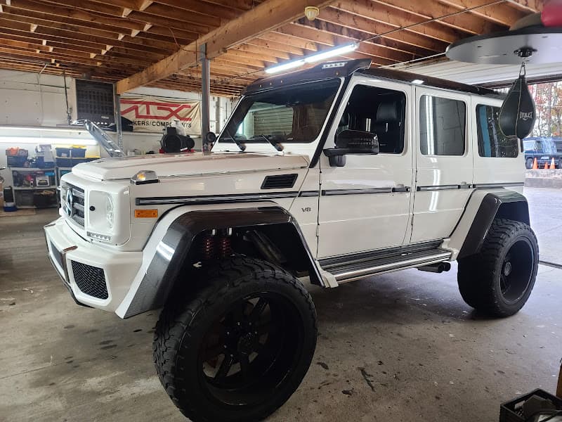 White lifted SUV with large black wheels in garage at T M Audio of Atlanta in Atlanta, Georgia