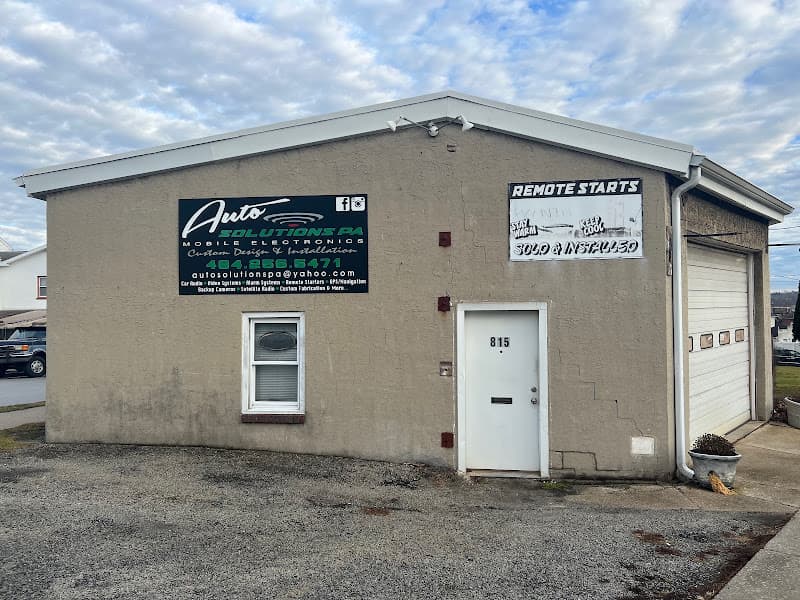 Tan stucco shop building with a sign reading Auto Solutions PA at AutoSolutions Pa in Bridgeport, Pennsylvania