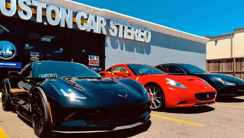 Black and red sports cars parked outside a storefront at Houston Car Stereo in Houston, Texas