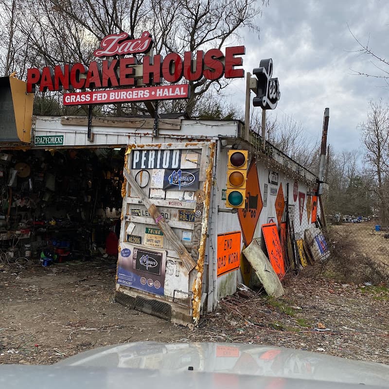 Shop front covered in road signs, with a red Pancake House sign at Crazy Chucks Shop in Bridgeport, New Jersey
