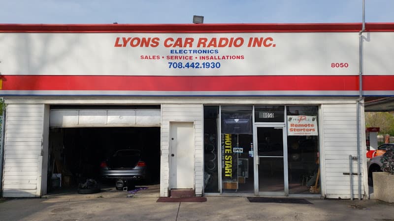 Storefront with an open garage bay and a sedan inside at Lyons Car Radio Inc in Lyons, Illinois