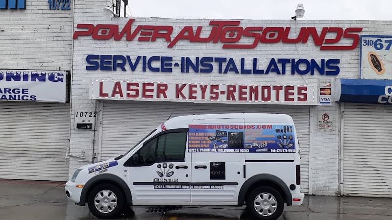 Storefront with roll-up doors, red sign and white van at Power Auto Sounds in Inglewood, California