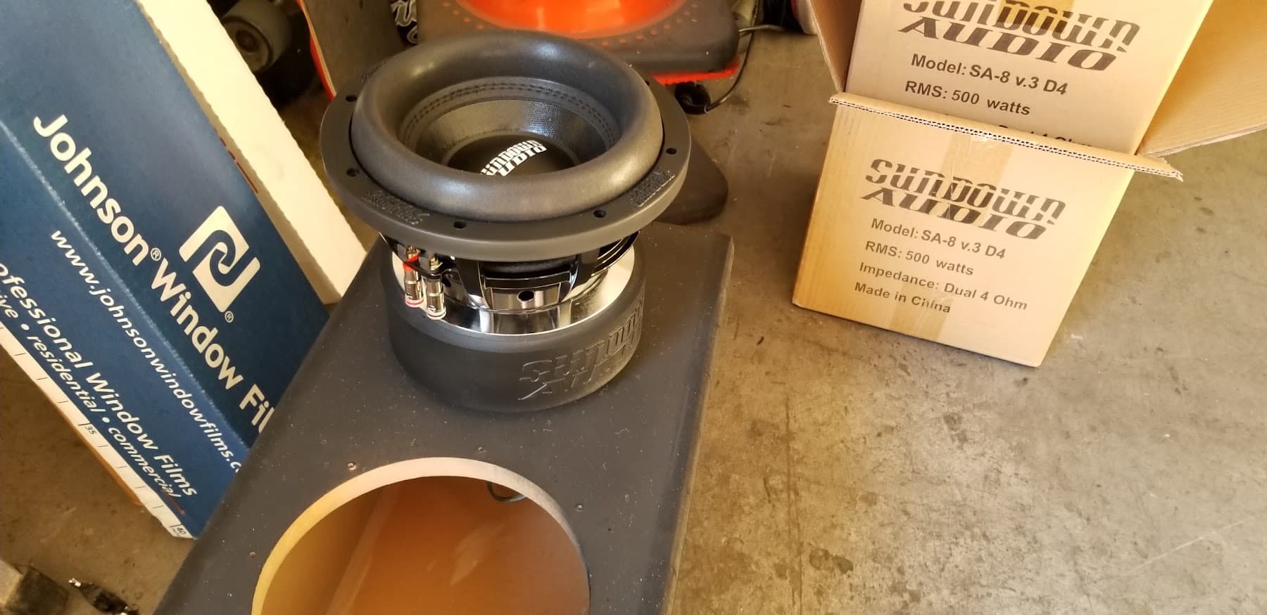 Sundown Audio SA-8 subwoofer on a black enclosure beside product boxes at 310 Kreations in Gardena, California