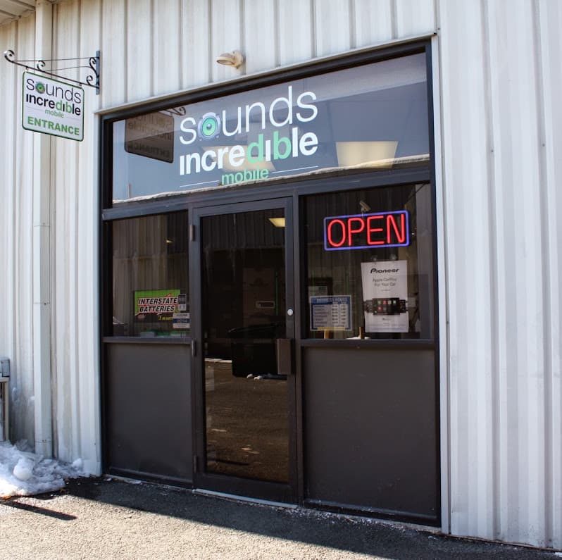 Glass storefront entrance with red OPEN sign at Sounds Incredible Mobile in Brookfield, Connecticut