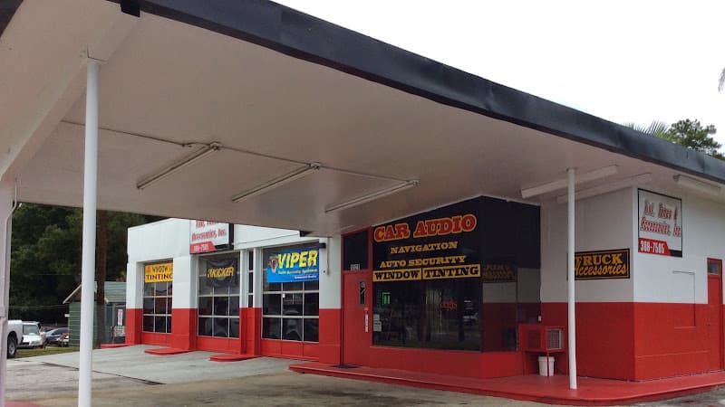 Red and white storefront with car audio and tinting signs at Tint Tunes & Accessories Inc in Jacksonville, Florida