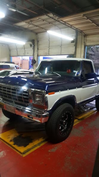 Navy and white pickup truck parked inside a shop bay at Custom Sound Works in Lubbock, Texas