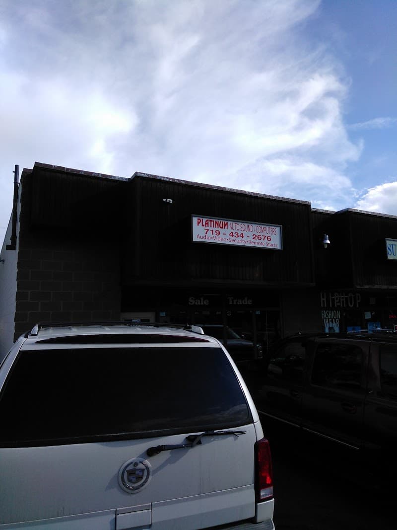 Dark storefront with Platinum sign and white SUV parked out front at Platinum Auto Sound in Colorado Springs, Colorado