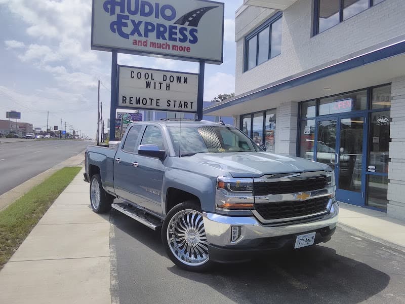 Blue-gray Chevrolet pickup truck with chrome wheels in front of storefront at Audio Express in Richmond, Virginia
