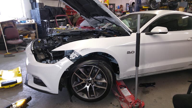 White coupe with open hood and front bumper removed at Ultimate Sound Solution in Warrington, Pennsylvania