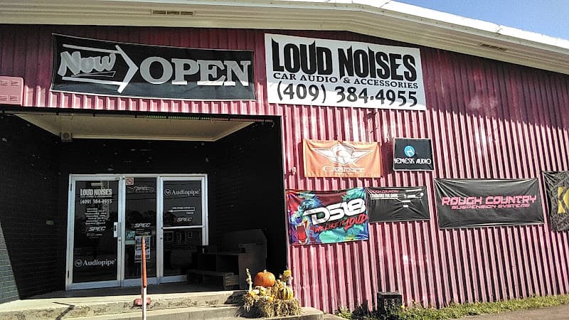 Storefront with Now Open banner and red metal siding at Loud Noises Car Audio in Jasper, Texas