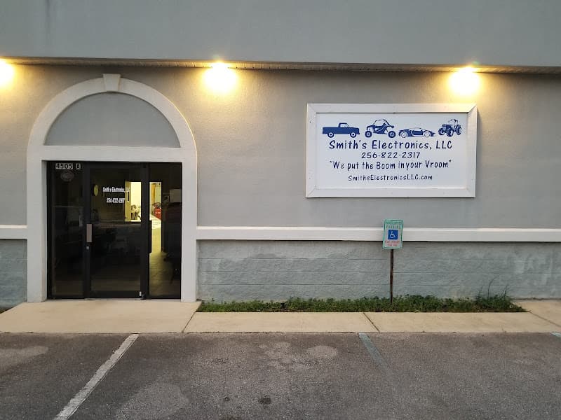 Building exterior with arched glass door and blue sign at Smith's Electronics LLC in Decatur, Alabama
