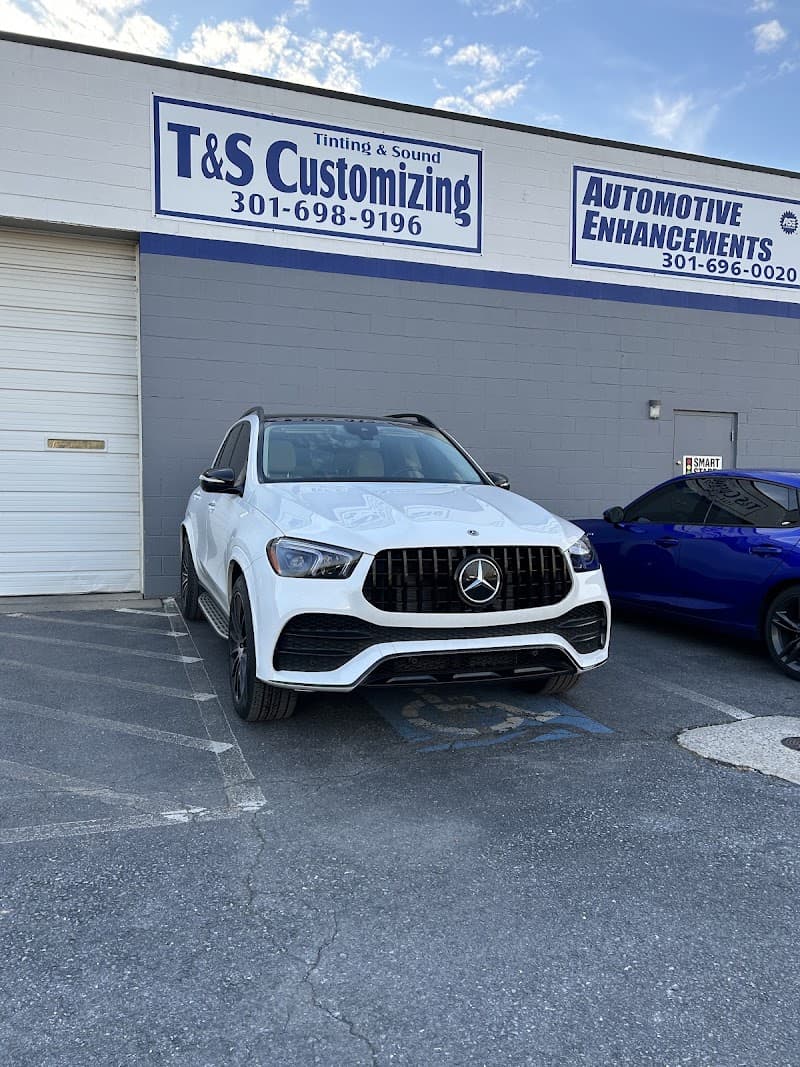 White Mercedes SUV parked outside a building with blue signs at Tint And Sound in Frederick, Maryland