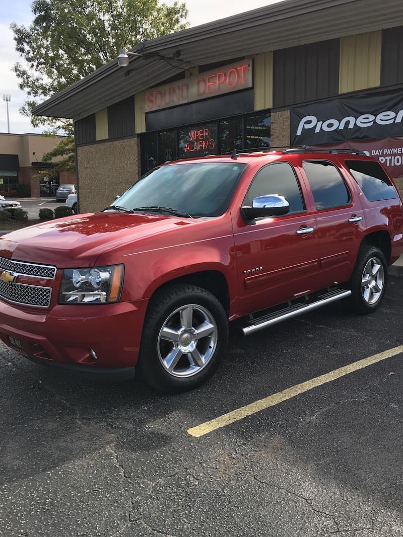 Red Chevrolet Tahoe SUV parked in front of a storefront at Sound Depot Inc in Madison, Alabama