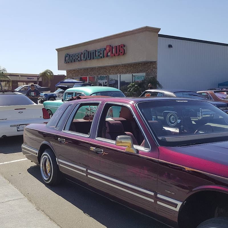 Maroon sedan with gold wheels in a parking lot at Bakersfield Car Audio and Stereo in Bakersfield, California