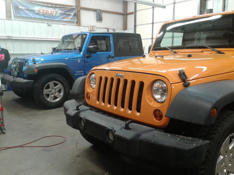 Orange Jeep and blue SUV parked in a shop bay at Redline Audio and Performance in Spindale, North Carolina
