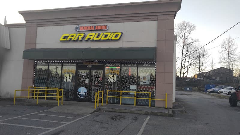 Storefront with yellow CAR AUDIO sign and metal-grate windows at General Audio in Doraville, Georgia