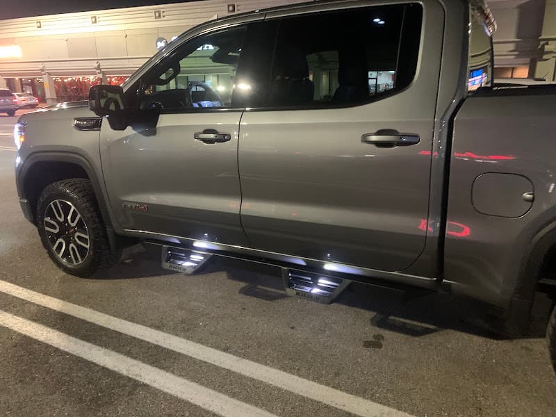 Gray pickup truck with lighted running boards in a parking lot at Jireh Audio in Houston, Texas