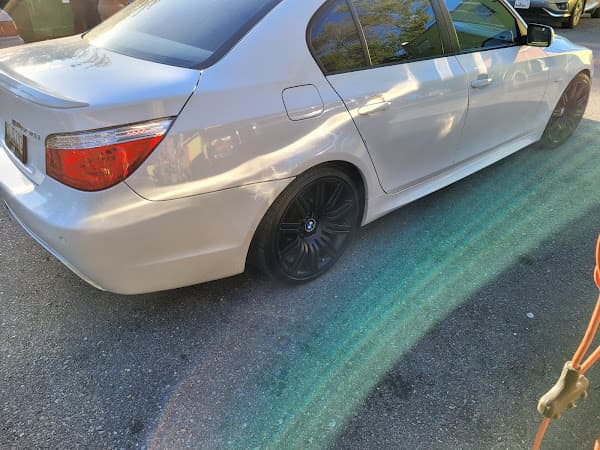 Rear three-quarter view of white BMW sedan with black wheels at Crazy Car Audio in College Park, Maryland