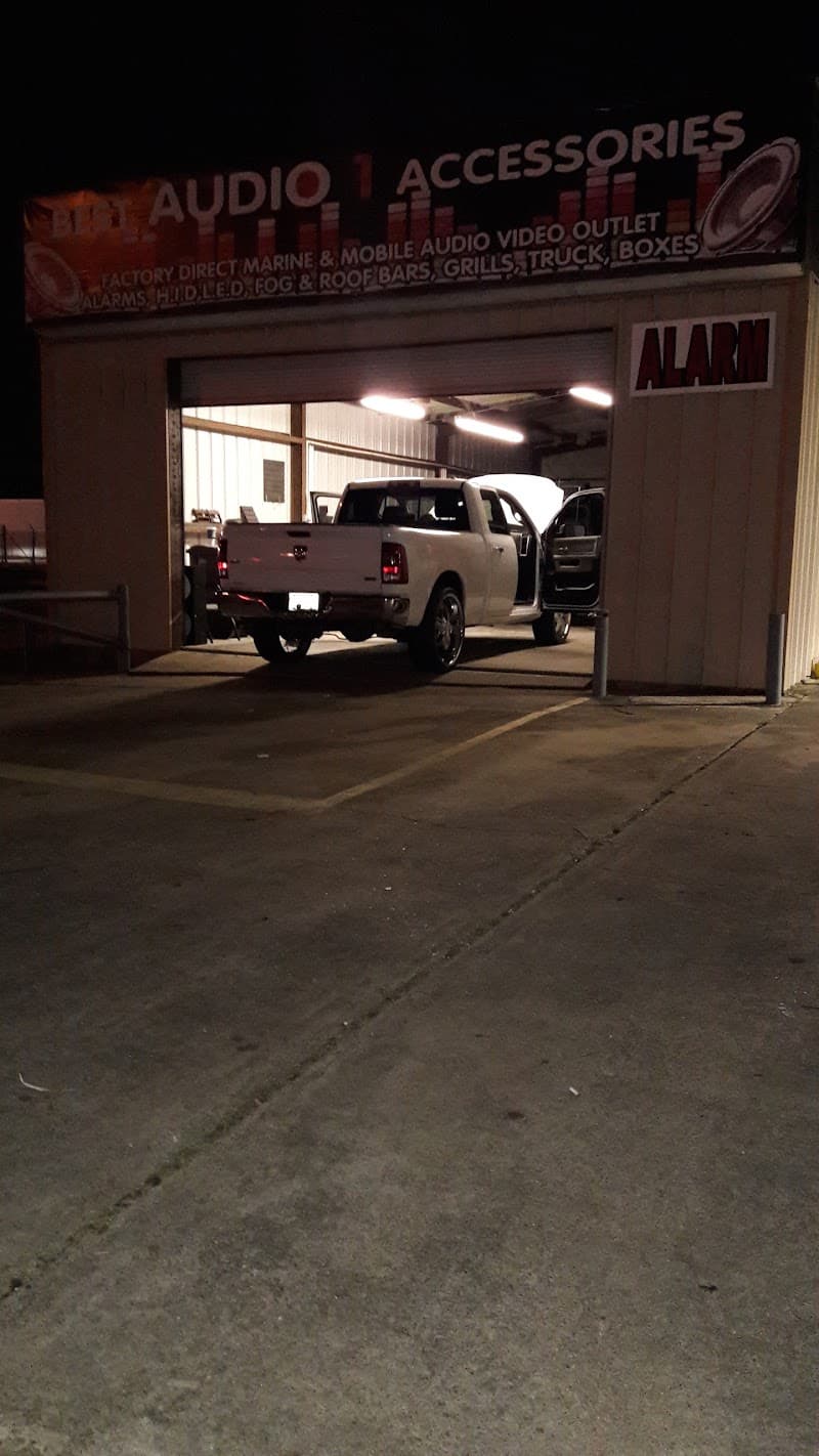 White pickup truck inside an open service bay after dark at Best Audio 1 Accessories in Beaumont, Texas