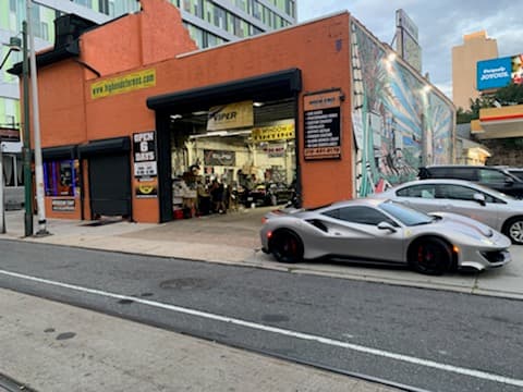Orange brick storefront with a sports car outside at High End Vine Street Car Stereo inc in Philadelphia, Pennsylvania