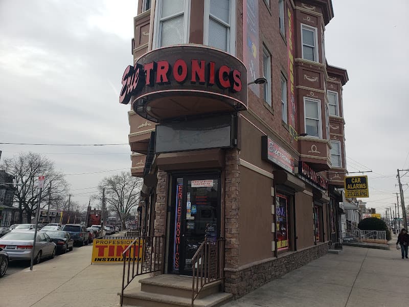 Corner storefront with a red Erietronics sign on a brick building at Erietronics Inc in Philadelphia, Pennsylvania