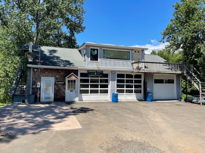 Two-story shop building with garage doors and Xpress Tints sign at Stereo Works LLC in Branford, Connecticut