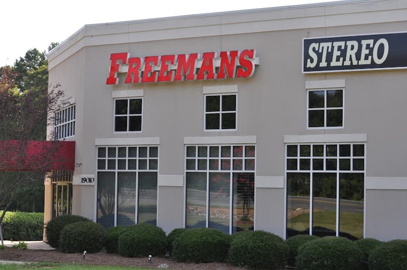 Two-story stucco building with red FREEMANS and STEREO signs at Freeman's Stereo Video in Cornelius, North Carolina