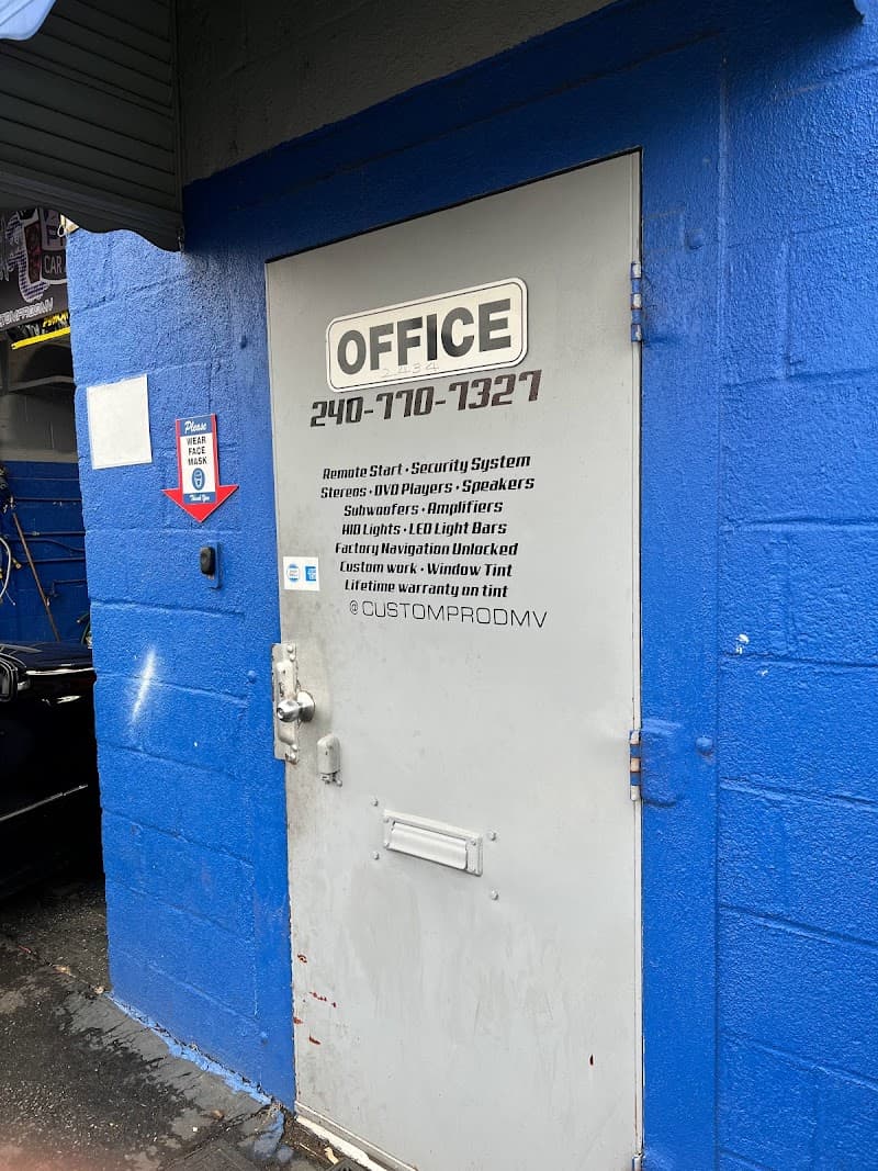 Gray office door on a blue block wall with a printed services list at Custom Pro Car Audio in Chillum, Maryland