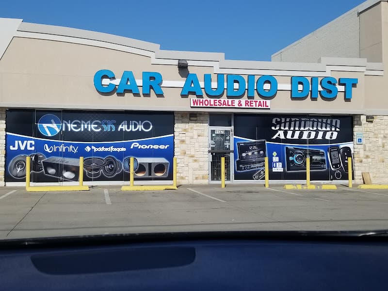 Storefront with blue sign and window decals for JVC and Pioneer at Car Audio Distributors in Dallas, Texas